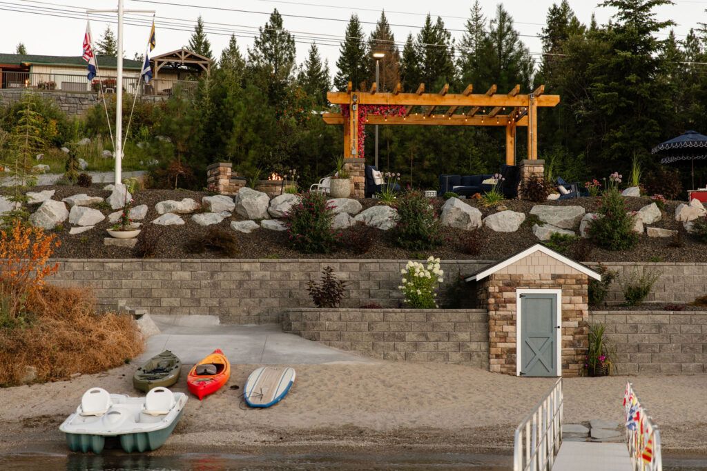 Outdoor living space on the lake including hardscaping, retaining wall, and more by Copper Creek Landscaping